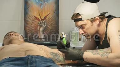 专业纹身师正在纹身沙龙`人手上做纹身
